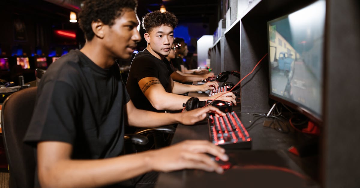 Group of young adults enjoying a competitive gaming session on computers indoors.