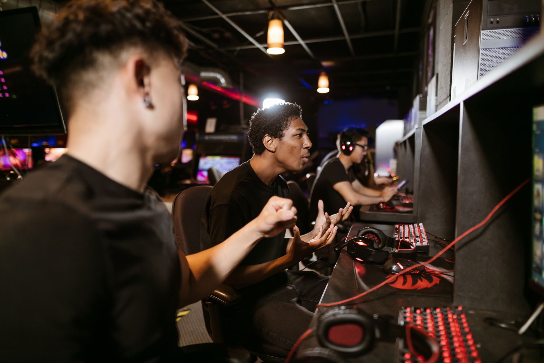 A group of young men intensely engaged in a competitive gaming session at an esports venue.