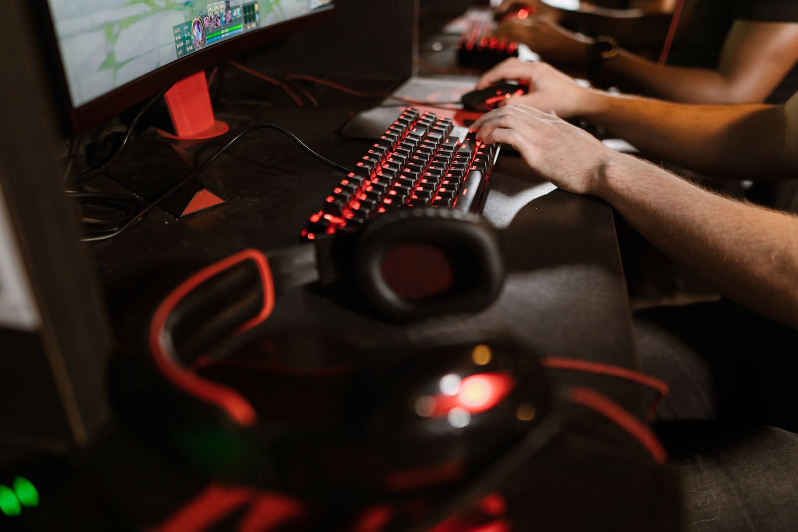 Esports player using a gaming keyboard, mouse, headset and monitor