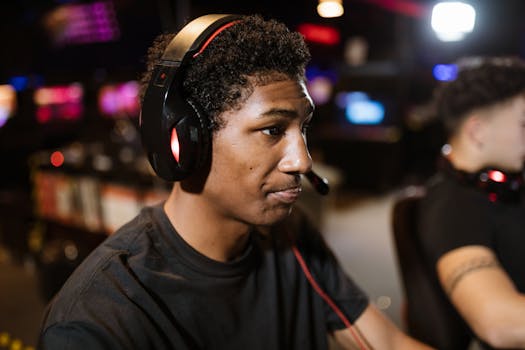 A young man wearing a headset intensely focused on gaming in a lively eSports arena.