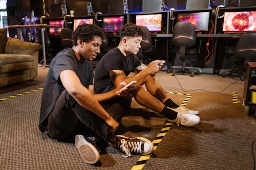 Two Men Sitting on the Floor while Playing