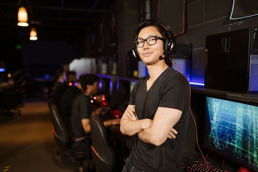 A confident adult gamer standing in a modern gaming room, smiling and wearing a headset.