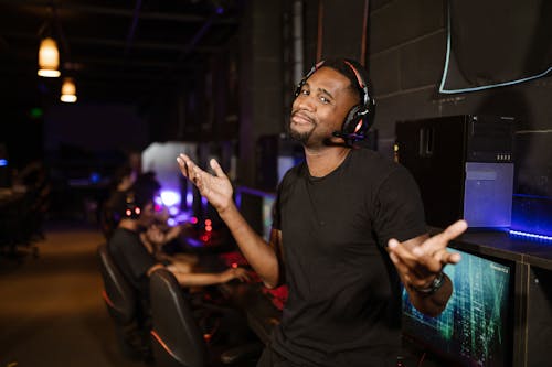 Man in Black Shirt Wearing Black Headphones while Smiling