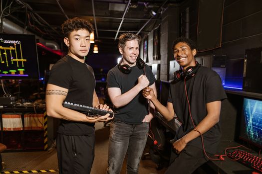 Three friends enjoying a gaming session with high-tech equipment and a joyful atmosphere.