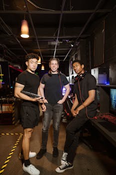 Three friends in a modern gaming lounge with headphones, keyboards, and vibrant screens.