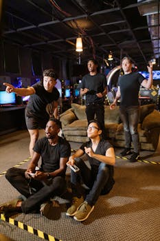 Five young adults gaming together in an arcade setting, enjoying teamwork and technology.