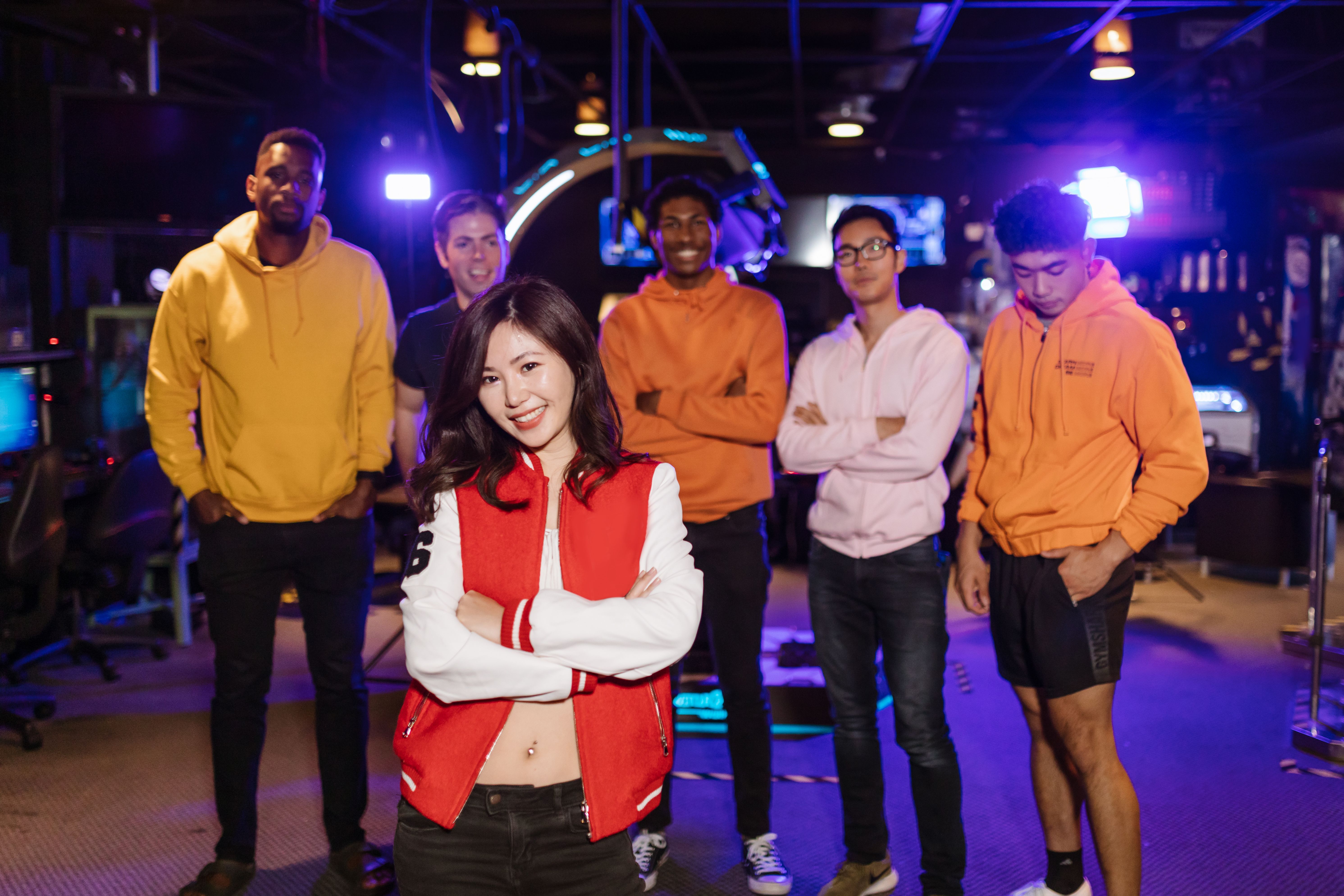 A diverse group of young adults enjoying time together in a lively arcade setting.