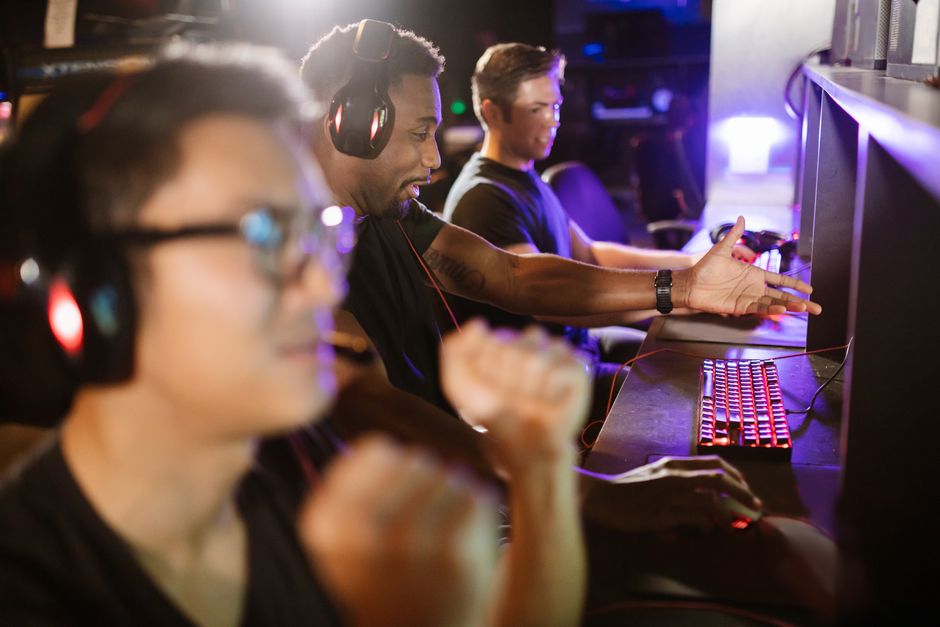 A group of diverse friends enjoying an intense gaming session in an indoor arcade setting.