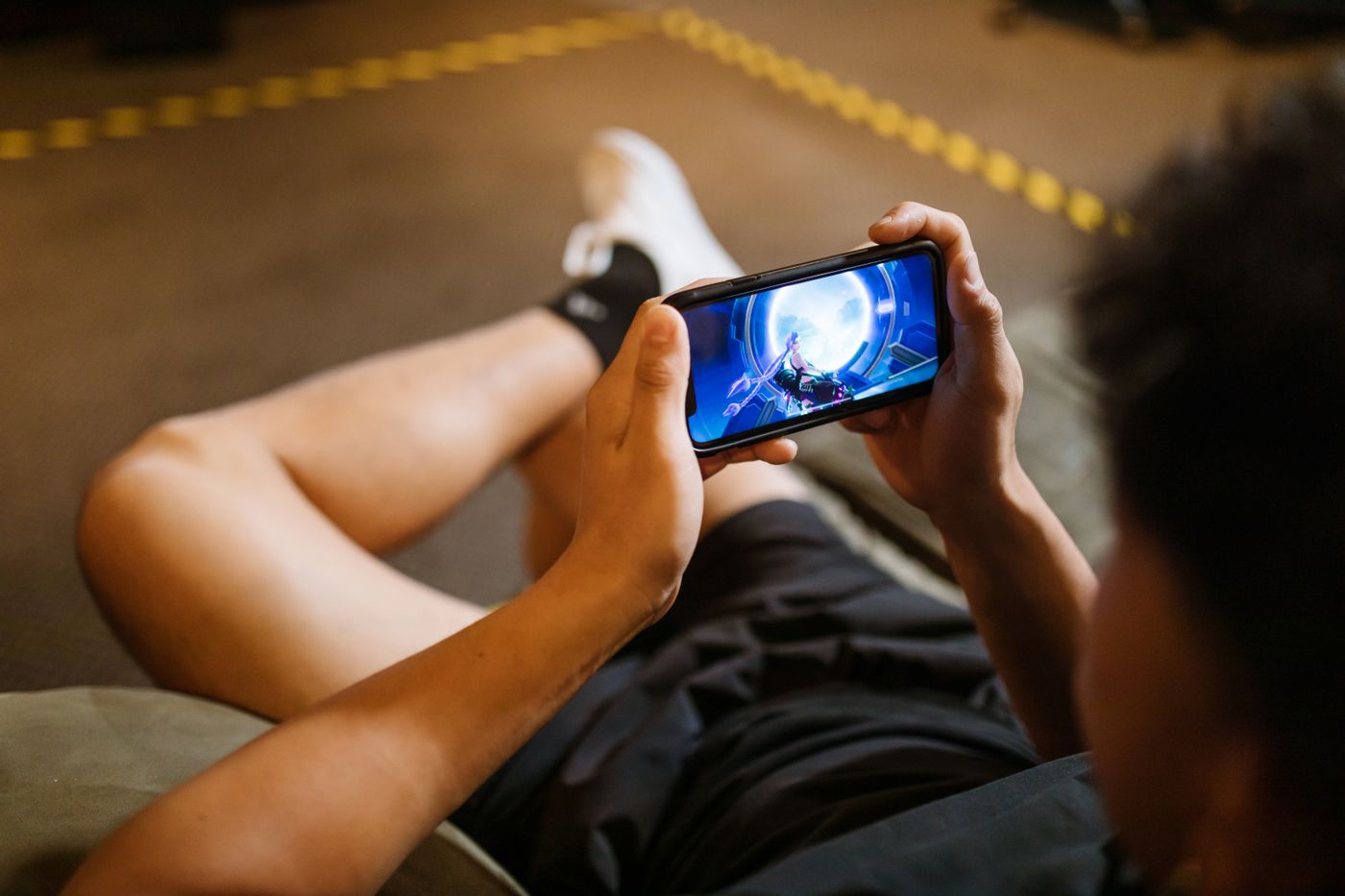 Pemain menggunakan smartphone untuk mobile gaming