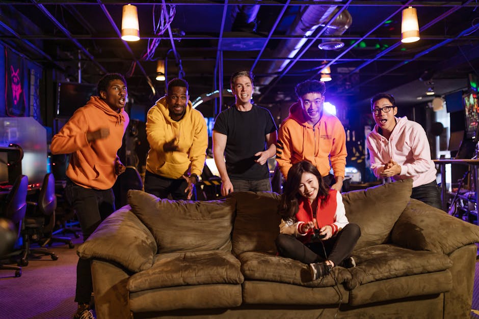 A diverse group of young adults enjoying video games together in a modern indoor setting with vibrant lighting.