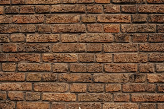 Detailed close-up of a rustic red brick wall showing texture and pattern.