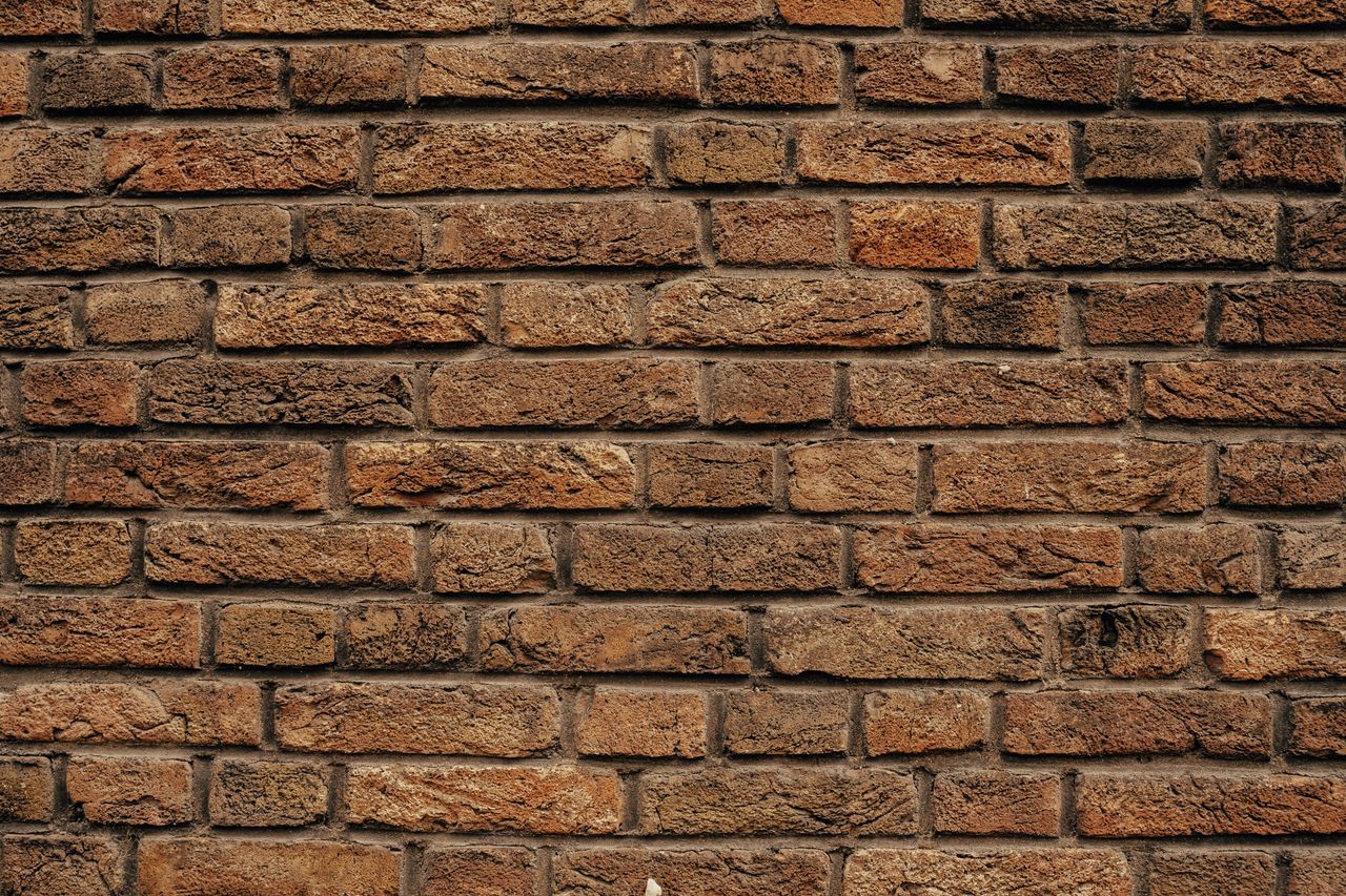detailed close up of a rustic red brick wall showing texture and patte