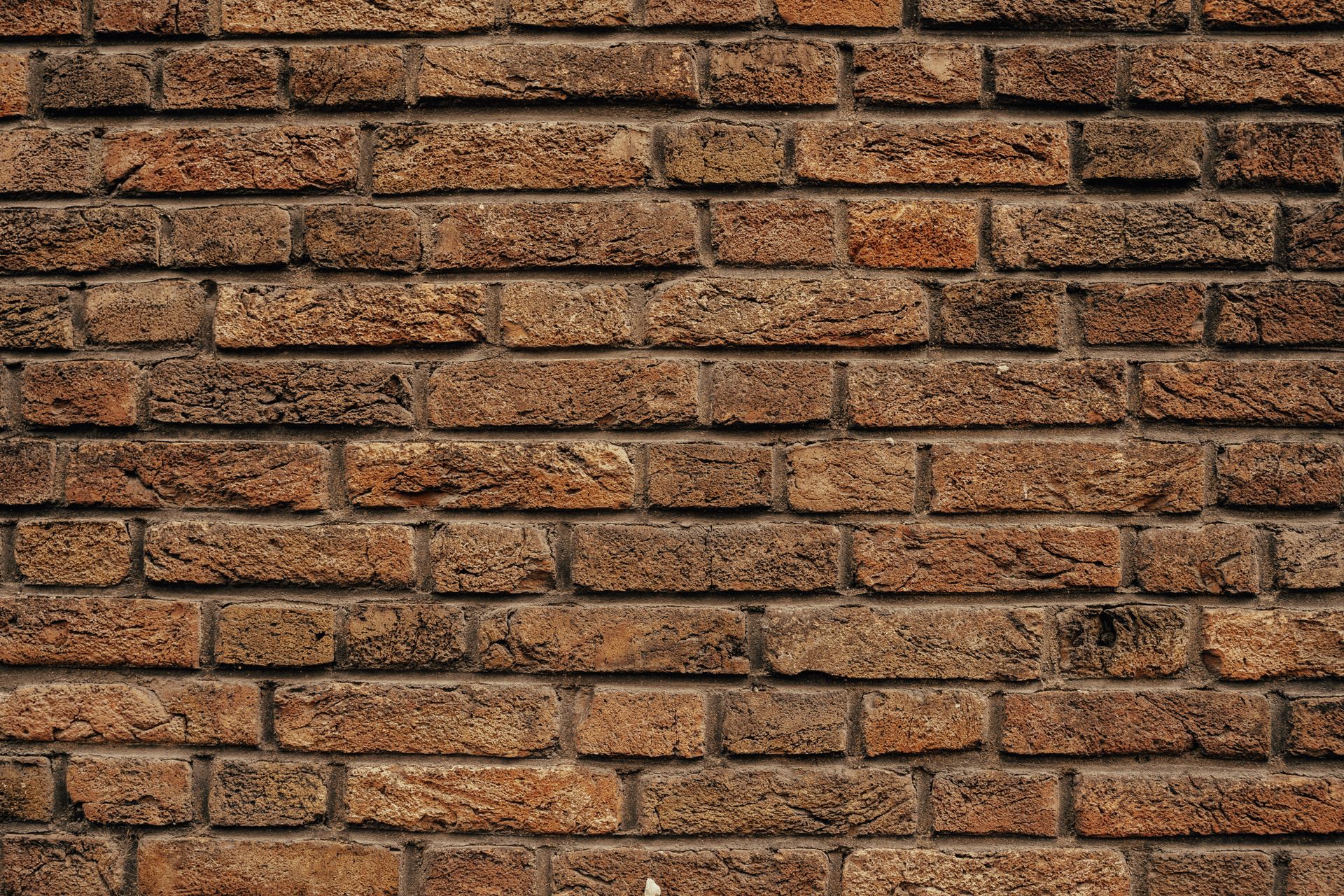 Detailed close-up of a rustic red brick wall showing texture and pattern.