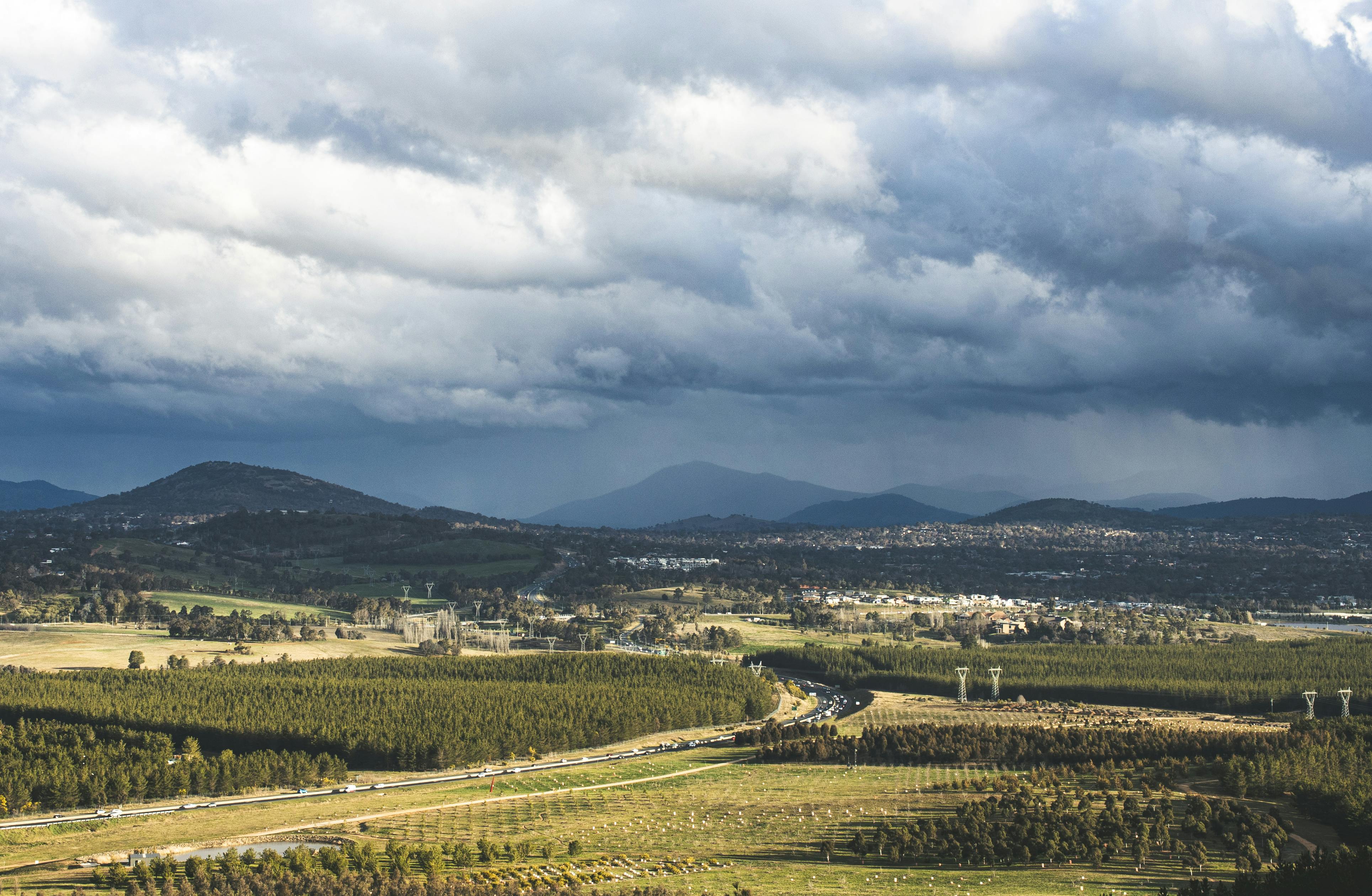 Stunning aerial view of Canberra's countryside with dramatic clouds overhead.