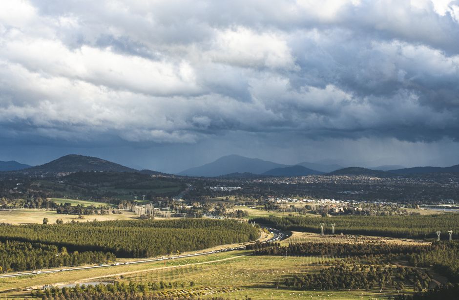 Stunning aerial view of Canberra's countryside with dramatic clouds overhead.