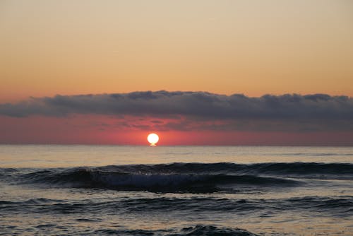 Free A Beautiful Sun Setting Over the Ocean Stock Photo