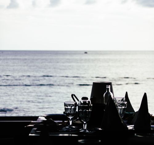 Free Elegant silhouette of a dinner setting with ocean view, capturing a serene seaside atmosphere. Stock Photo