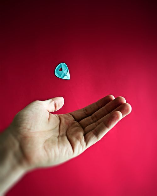 Free Dynamic image of a hand tossing a guitar pick on a vibrant red background. Stock Photo