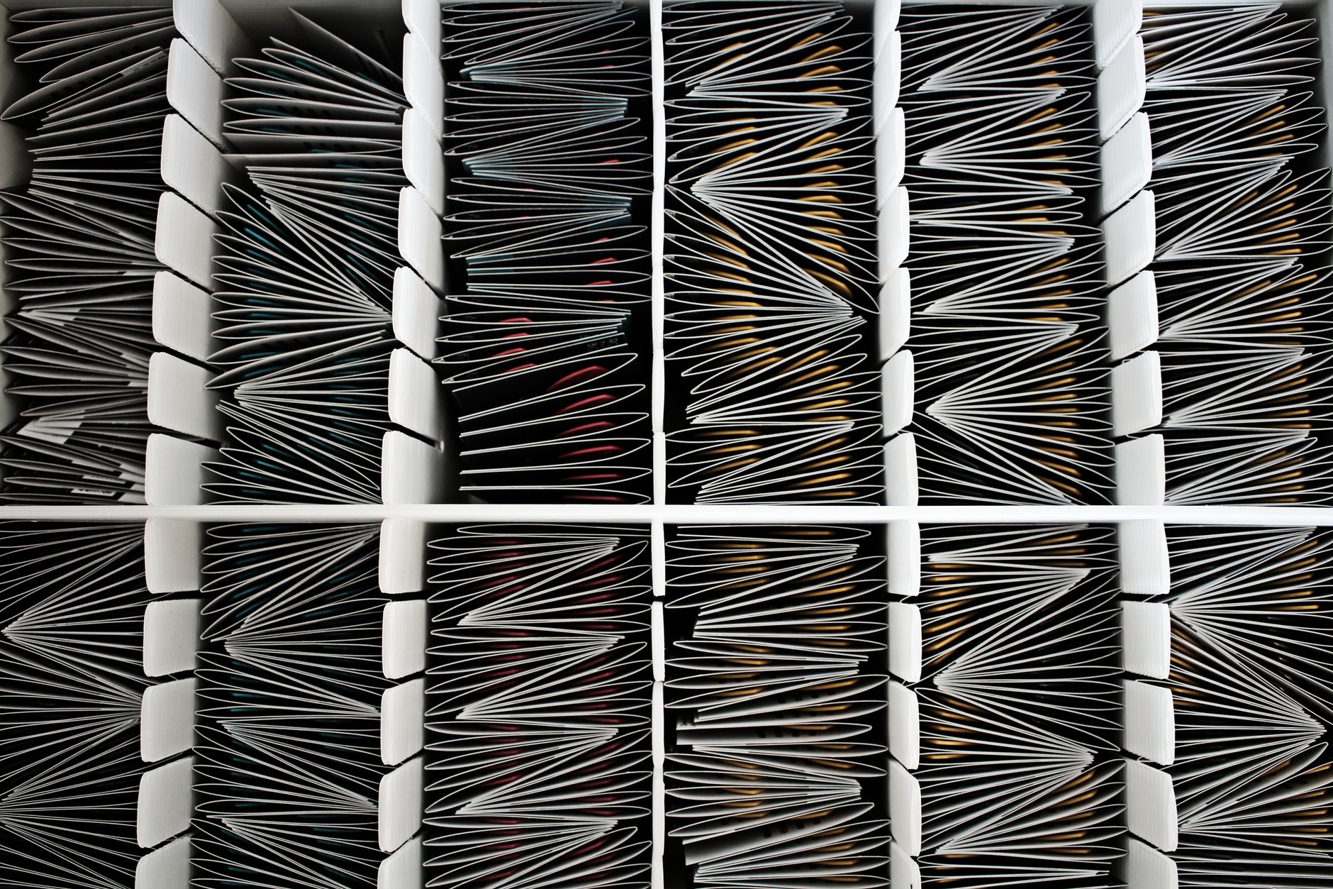 Top view of neatly organized documents divided by separators in a container.