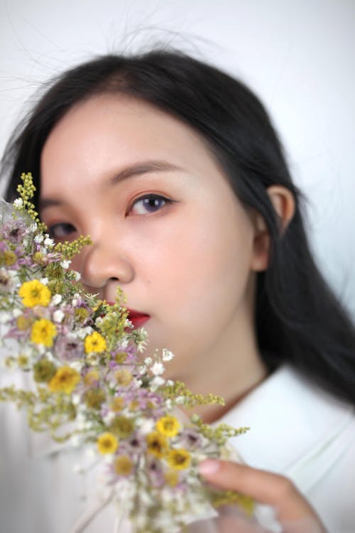 Close Up Photo of a Girl with Half  Face Covered with Flowers 
