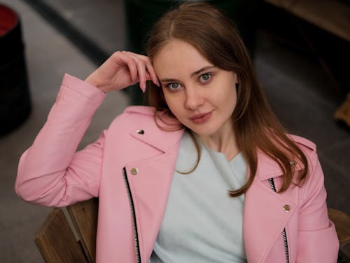 Woman Wearing Pink Leather Jacket Sitting on a Chair