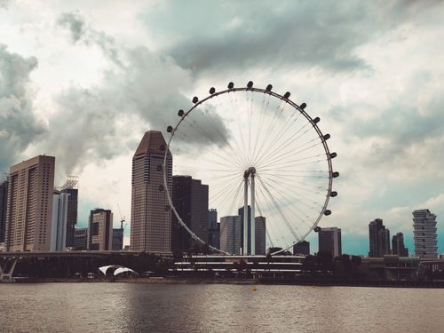 Free Captivating view of Singapore's skyline featuring the towering Singapore Flyer Ferris wheel. Stock Photo