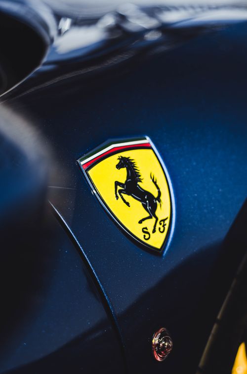 Free Detailed close-up of a luxury sports car logo on a sleek black vehicle. Stock Photo
