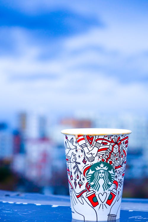 흰색과 빨간색 스타 벅스 일회용 컵의 클로즈업 사진