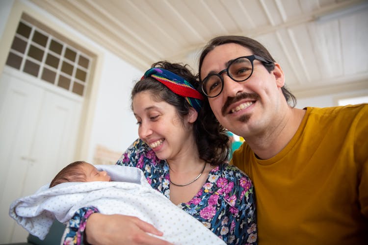 A Man In Yellow Shirt Taking Selfie With His Baby And Wife