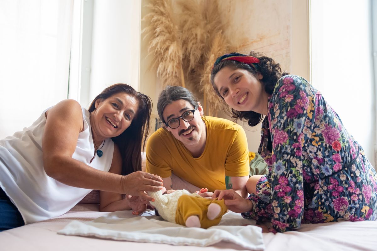 Family smiling with a newborn at home