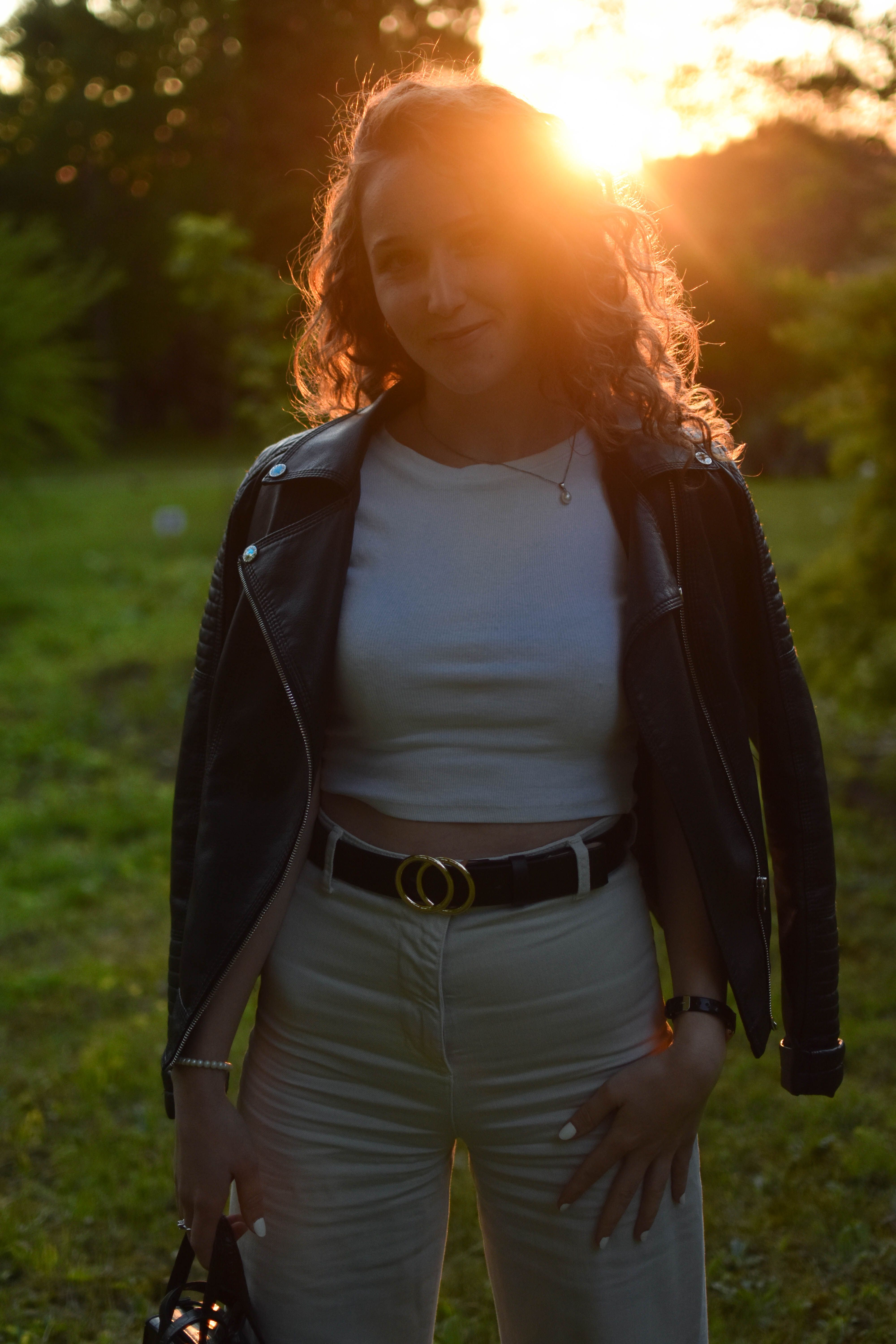 Woman in Black Leather Jacket Standing on Green Grass · Free Stock Photo