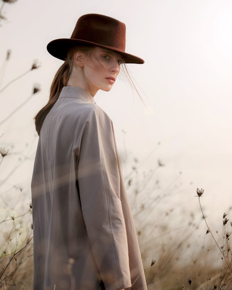 Woman In Stylish Har And Gray Coat In Field