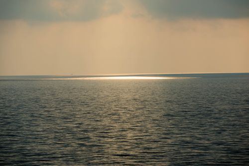 Free Peaceful seascape at sunrise in Singapore with calm ocean and gentle horizon glow. Stock Photo