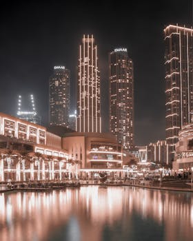 Night view of Dubai's towering skyscrapers with stunning water reflections.