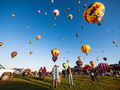 Colourful hot air balloons over a festival — Raychel Sanner on Pexels