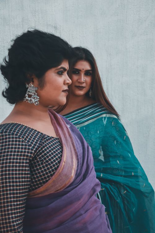 Free Two Indian women in traditional sarees pose elegantly showcasing cultural fashion. Stock Photo