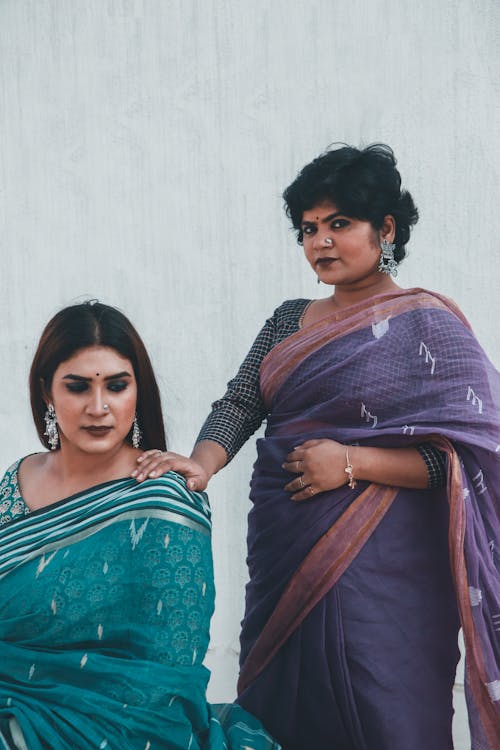 Woman in Blue and Brown Sari Beside Woman in Black and White Long Sleeve Dress