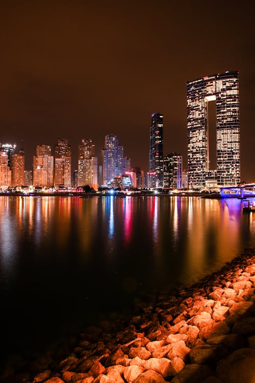 Free City Skyline Across Body of Water during Night Time Stock Photo