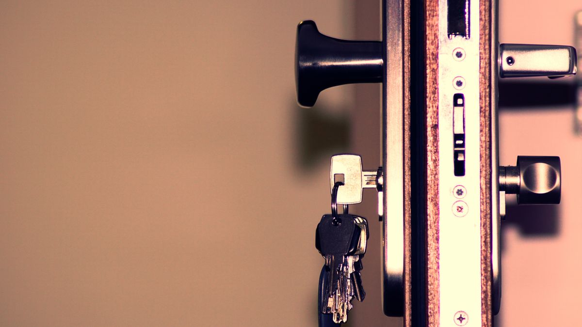 Serrure encastrée sur le chant d'une porte blanche, avec ses clés