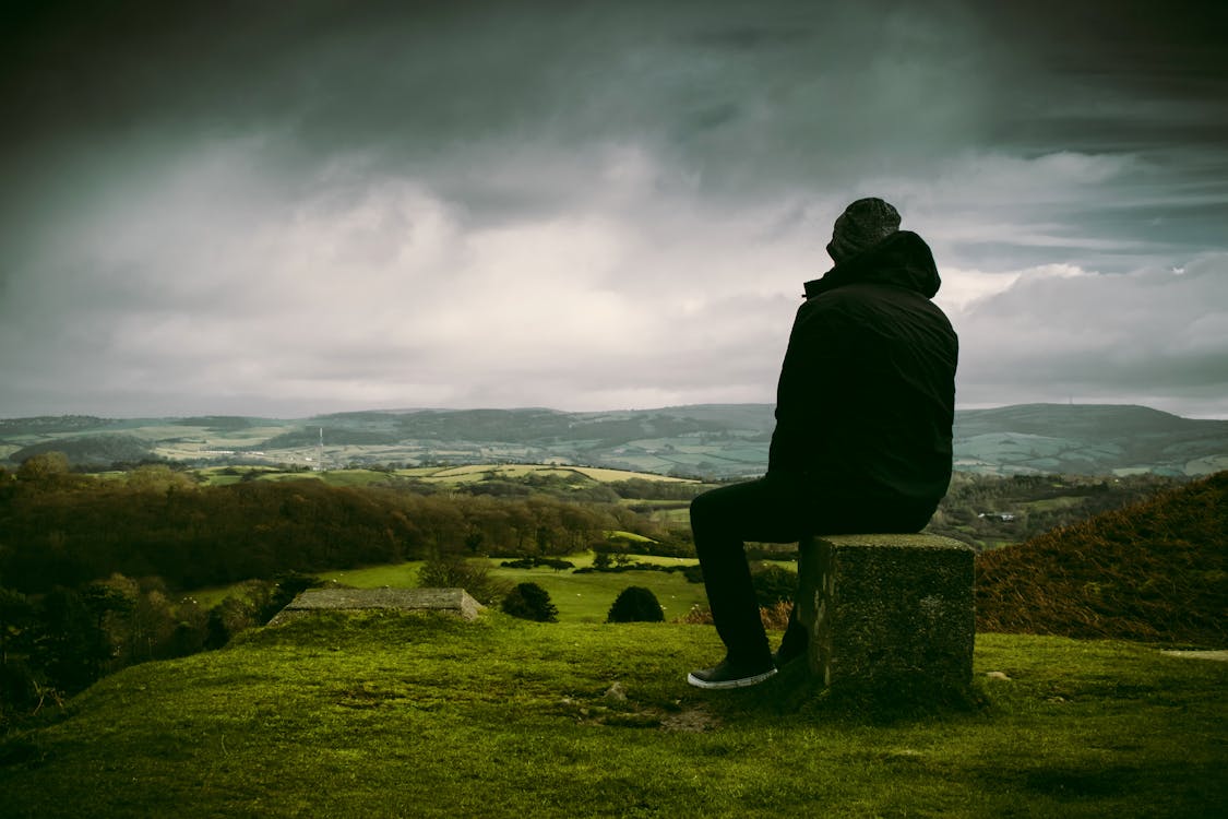 Free Man in Black Jacket Sitting on Block Stock Photo