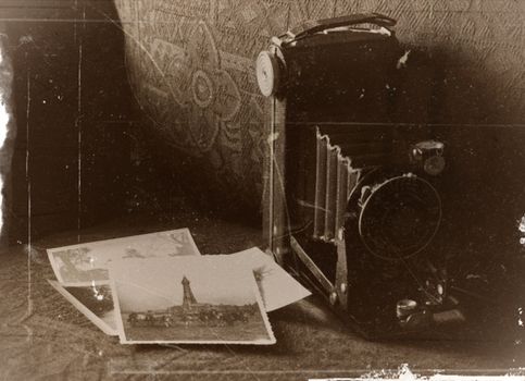 Sepia-toned image of a vintage camera with old photographs, capturing nostalgic memories.