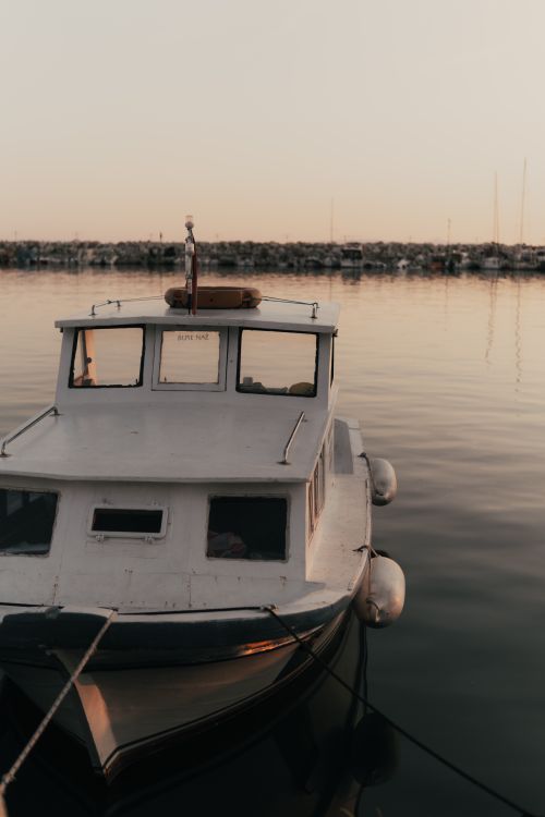 Free A tranquil scene of a docked boat at sunset in Balıkesir, Türkiye. Stock Photo