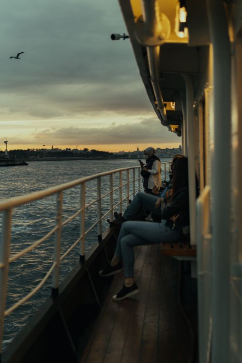 People Riding Ship People Sitting on Ships Deck at Dawn · Free Stock Photo
