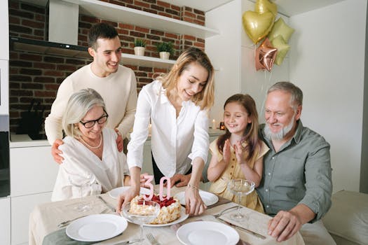 A joyful family gathering around a table celebrating a 30th birthday with a cake and balloons.