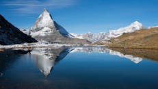 瑞士阿尔卑斯山平静的湖面上，倒映着令人惊叹的马特峰，四周环绕着白雪皑皑的山峰