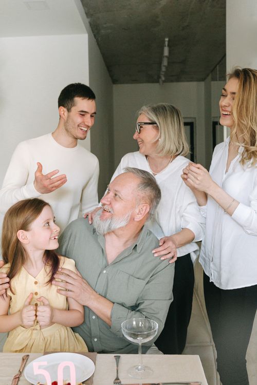 Free A joyful family gathering indoors celebrating a significant milestone with smiles and conversation. Stock Photo
