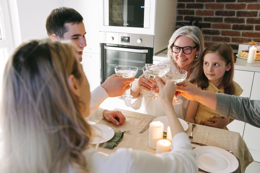 Family raising a gentle toast together around a candlelit table