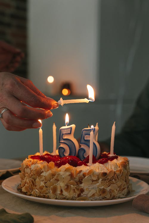 Free Person Holding a Lighted Candles Above a Birthday Cake Stock Photo