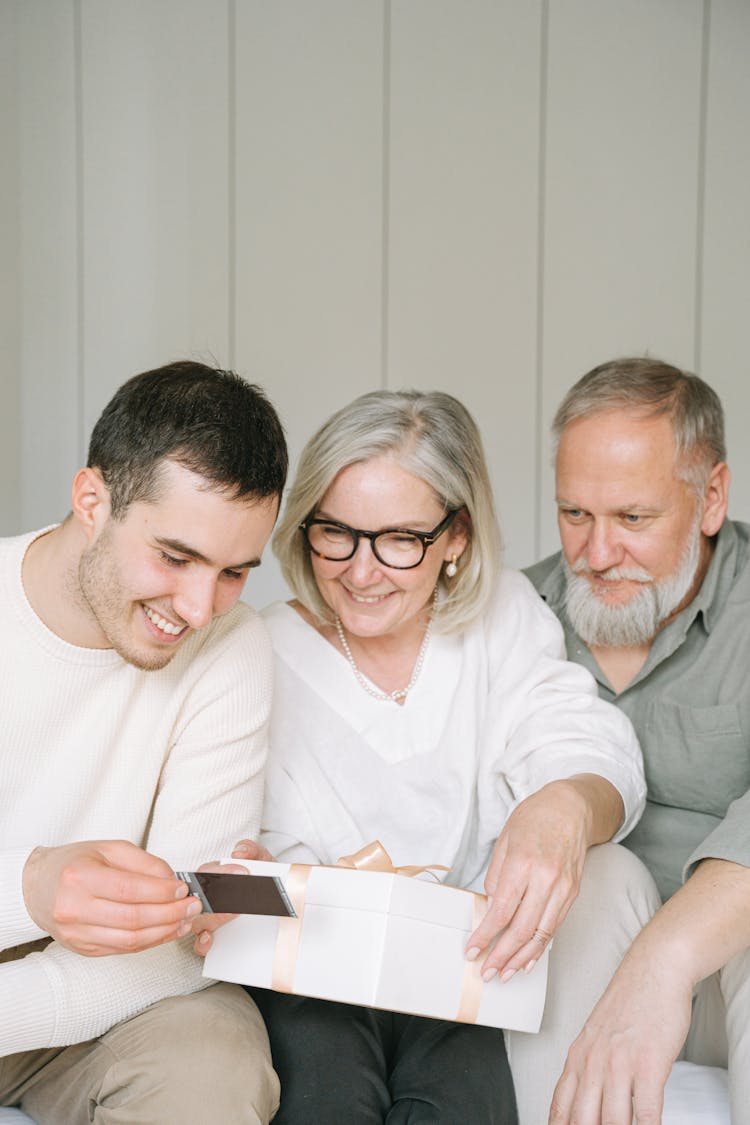 A Man Showing An Elderly Couple A Polaroid Photograph