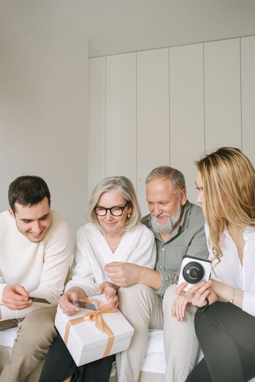 Free A joyful multigenerational family gathering, sharing gifts and smiles indoors. Stock Photo